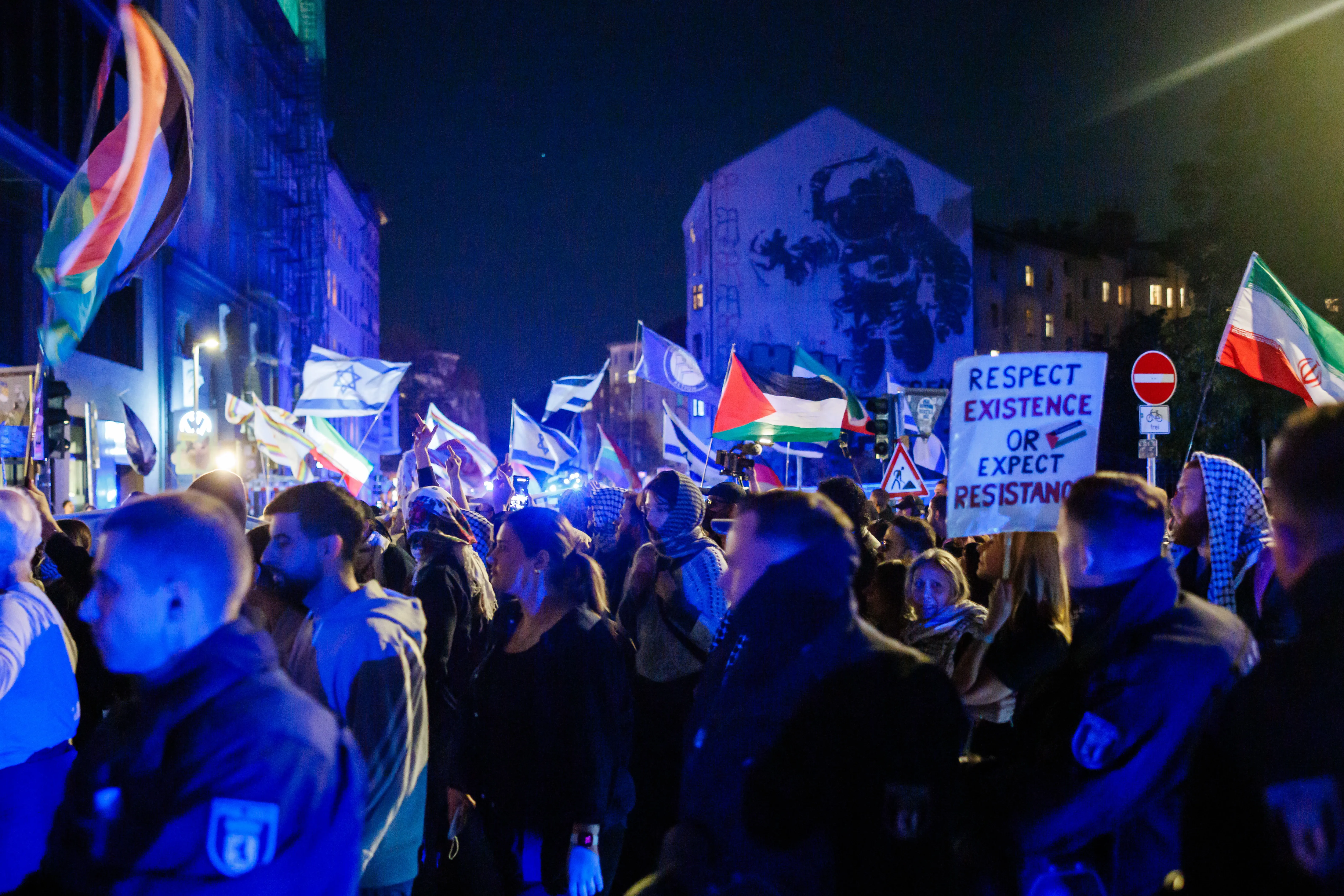 Protestierende mit palästinensischen Fahnen ziehen an einer Gegenkundgebung mit israelischen Fahnen vorbei (Berlin, 7. Oktober 2026)