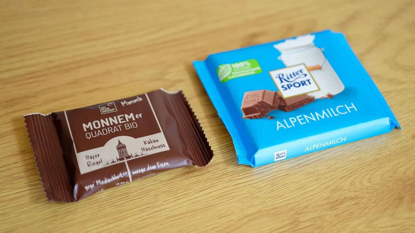 Schokolade gegen Haferriegel: Warum Ritter Sport jetzt gegen das „Monnemer Quadrat Bio“ kämpft